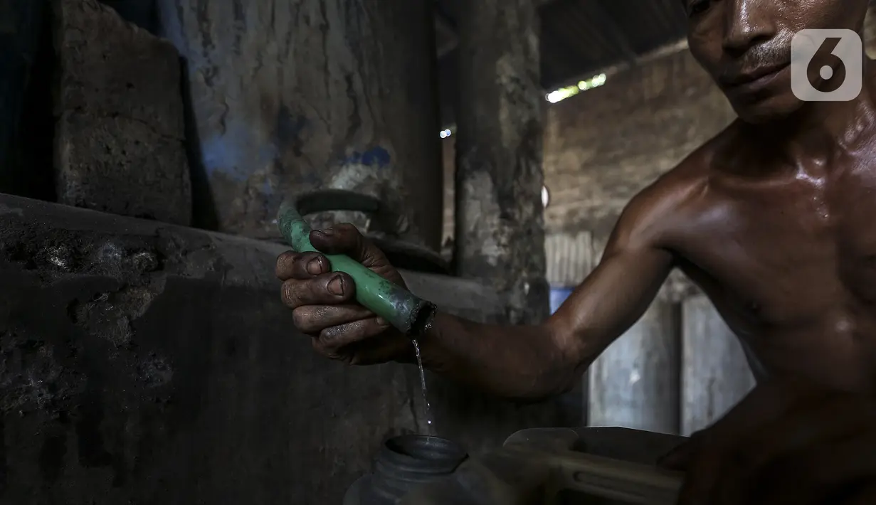 Pekerja memproses alkohol tradisional di industri rumahan Desa Bekonang, Kecamatan Mojolaban, Kabupaten Sukoharjo, Jawa Tengah, Rabu (18/11/2020). Untuk ukuran 200 liter tetes tebu, proses penyulingan membutuhkan waktu selama tiga-empat jam (Liputan6.com/Johan Tallo)