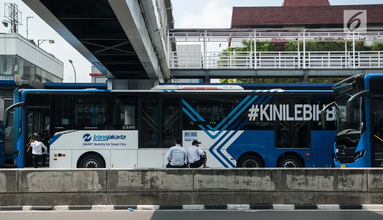 Sejumlah supir duduk didekat Bus Transjakarta yang mogok kerja di Halte Harmoni, Jakarta (12/6). Petugas transjakarta yang mogok kerja ini juga menurunkan penumpang di Jalan KH Hasyim Ashari sebelum halte Harmoni. (Liputan6.com/Gempur M Surya)