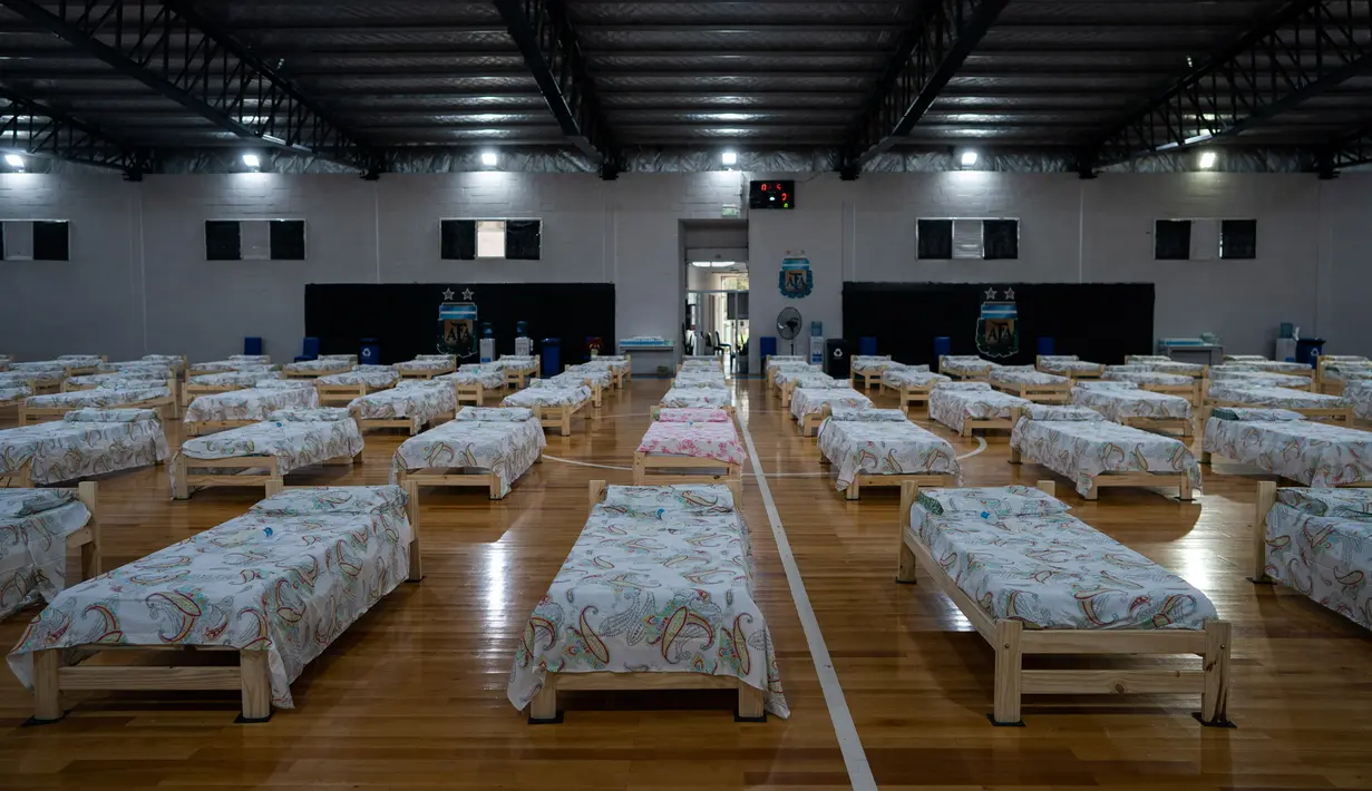 Tempat tidur untuk pasien terinfeksi virus corona Covid-19 diletakkan di gimnasium tempat berlatih timnas futsal Asosiasi Sepakbola Argentina (AFA) di pinggiran Buenos Aires, Senin (13/4/2020). Sekitar 120 tempat tidur tersedia di markas timnas futsal AFA untuk merawat pasien. (AP/Victor R. Caivano)