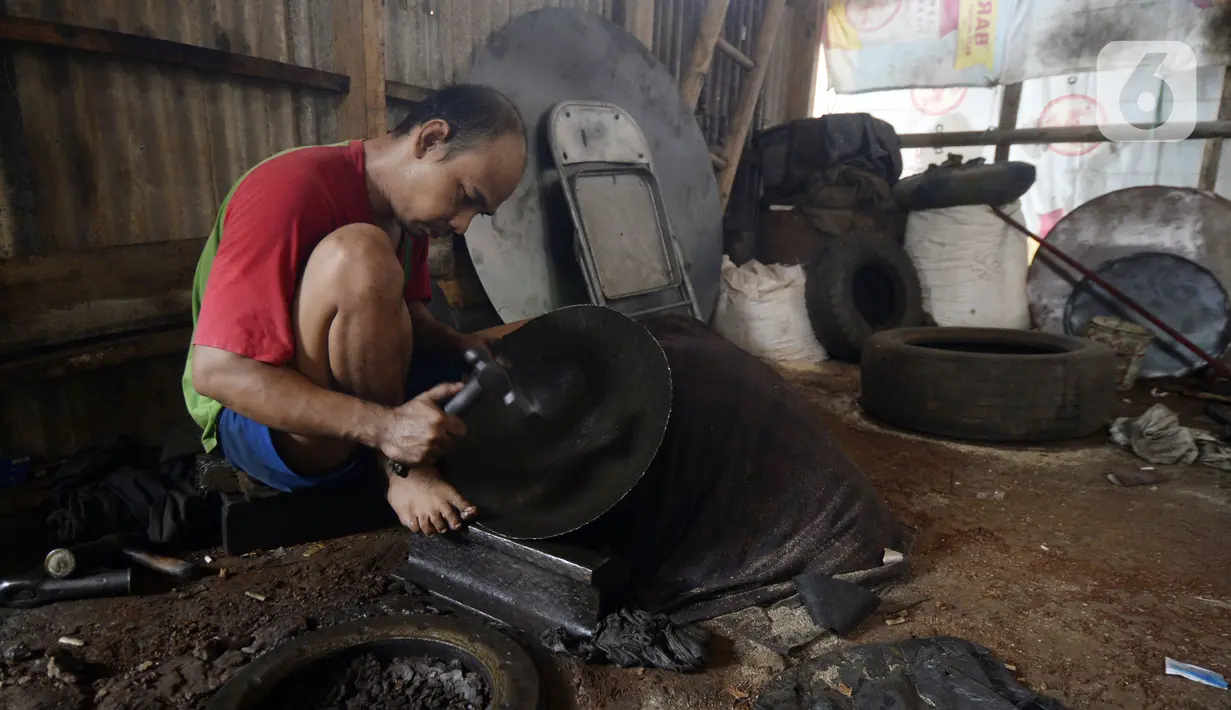 Perajin menyelesaikan pembuatan wajan yang terbuat dari pelat besi di Desa Cibadak, Tanah Sareal, Kabupaten Bogor, Jawa Barat, Rabu (5/8/2020). Pemerintah akan memberi bantuan Rp 2,4 juta dan kredit bunga rendah kepada UMKM untuk membantu pemulihan ekonomi nasional. (merdeka.com/Dwi Narwoko)