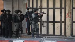 Seorang tentara Israel membidikkan senapannya ke arah demonstran Palestina saat terjadi bentrokan usai aksi demonstrasi menolak rencana aneksasi Israel di Kota Hebron, Tepi Barat, Jumat (3/7/2020). (Xinhua/Mamoun Wazwaz)