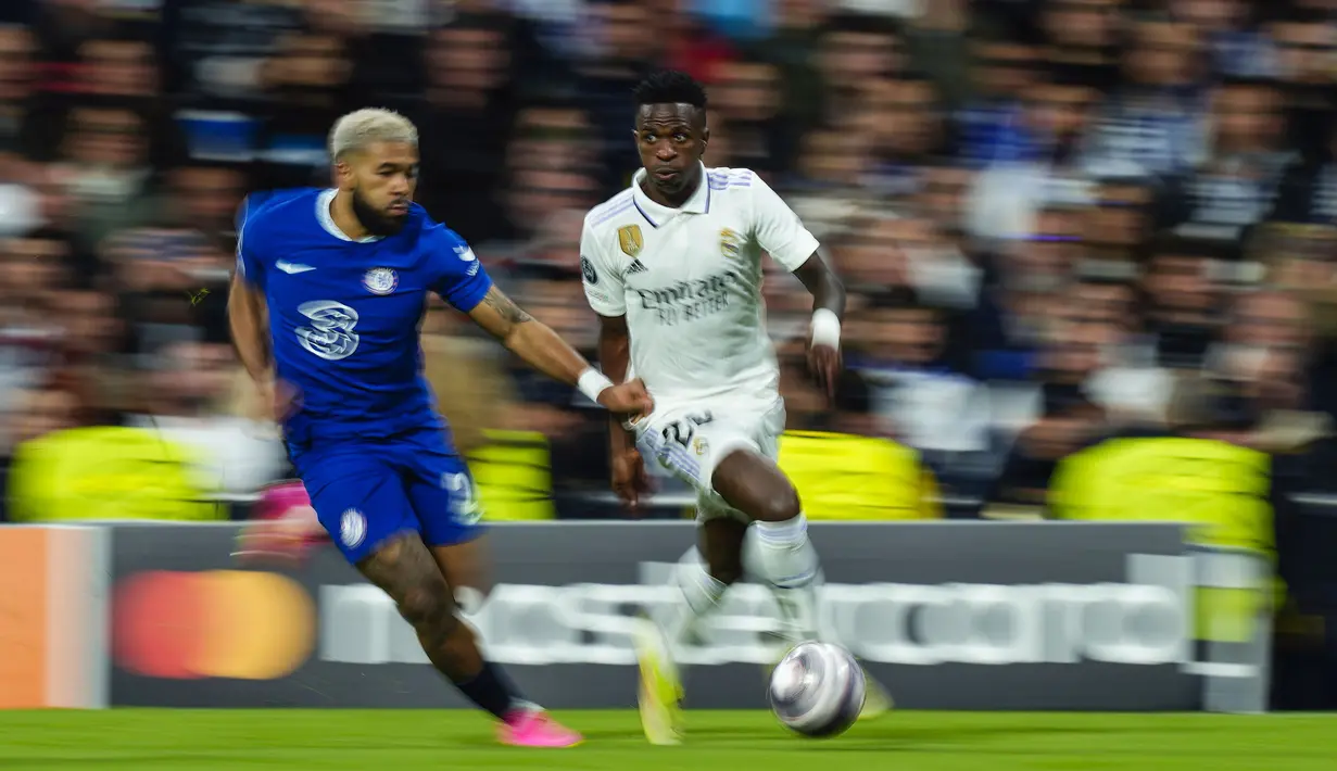 Pemain Real Madrid, Vinicius Junior (kanan) berebut bola dengan pemain Chelsea, Reece James pada laga leg pertama perempat final Liga Champions 2022/2023 di Santiago Bernabeu, Madrid, Kamis (13/04/2023) WIB. Los Blancos menang dengan skor 2-0. (AP Photo/Jose Breton)