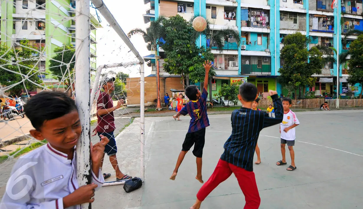 Sejumlah anak-anak warga penghuni rusun tampak ceria saat bermain di lapangan futsal yang ada di Rusun Muara Kapuk, Jakarta, Jumat (22/4/2016). Rusun Muara Kapuk sediakan lapangan sebagai sarana bermain untuk anak-anak.(Liputan6.com/Yoppy Renato)