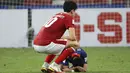 Pemain Timnas Indonesia, Elkan Baggott berusaha menghibur pemain Singapura, Faris Ramli yang masih meratapi kekalahan dari Indonesia. (AP/Suhaimi Abdullah)