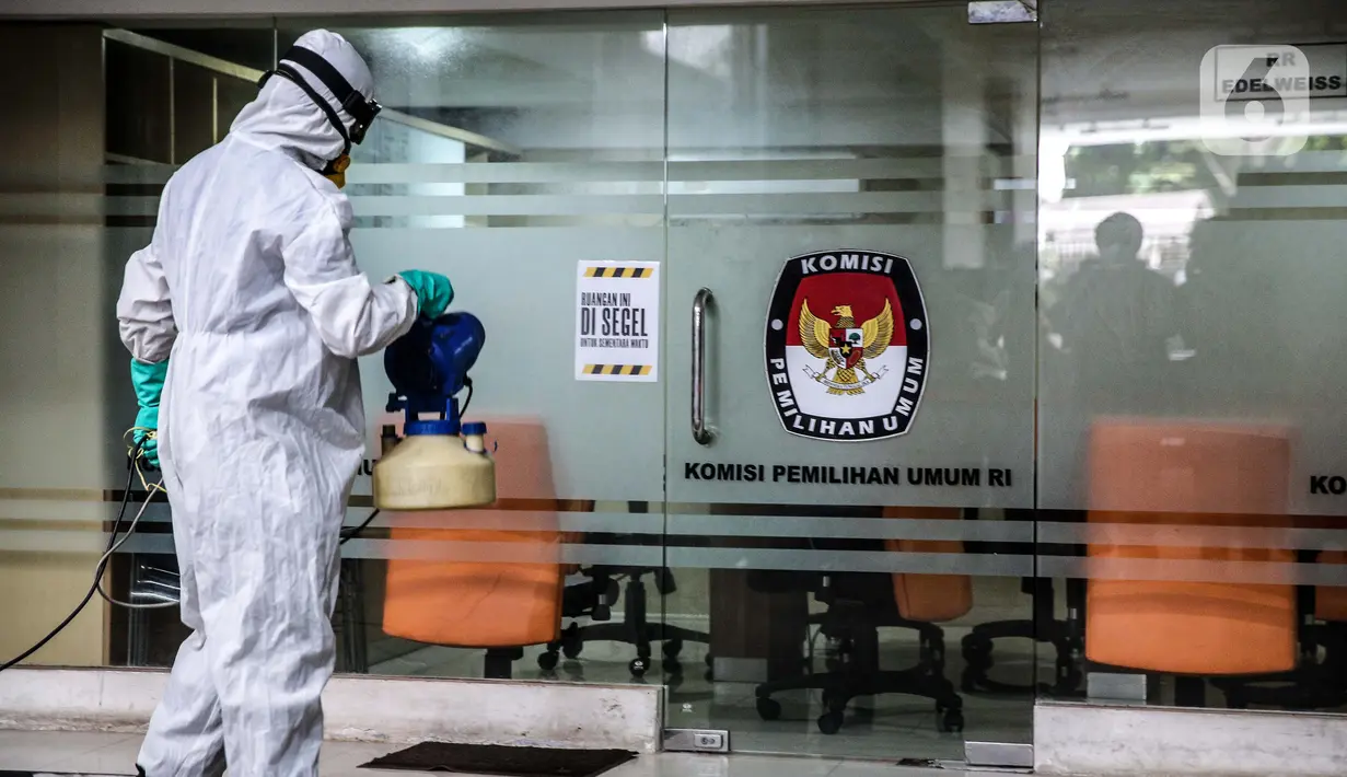 Petugas melakukan penyemprotan cairan disinfektan di salah satu ruangan yang segel di Gedung KPU Pusat, Jakarta, Selasa (21/7/20).  Penyemprotan dilakukan setelah seorang pegawai Komisi Pemilihan Umum (KPU) RI terpapar virus Covid-19. (Liputan6.com/Faizal Fanani)