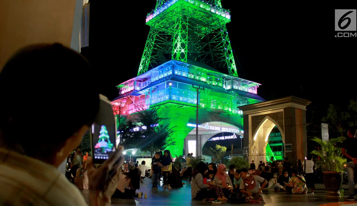 Warga mengambil gambar Pakaya Tower di kawasan taman Limboto, Kabupaten Gorontalo, Sabtu (12/1). Pengunjung dapat menikmati pemandangan Gorontalo dari puncak Pakaya Tower. (Liputan6.com/Arfandi Ibrahim)