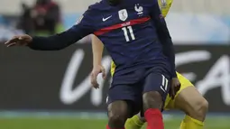 Penyerang Prancis, Ousmane Dembele mengontrol bola dari kawalan pemain Ukraina, Vitaliy Mykolenko pada pertandingan kualifikasi Piala Dunia D di stadion Start de France, di Saint Denis, utara Paris, Kamis (25/3/2021). Prancis bermain imbang atas Ukraina 1-1. (AP Photo/Thibault Camus)