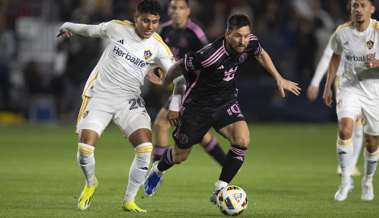 Pemain Inter Miami, Lionel Messi (kanan) berebut bola dengan pemain LA Galaxy, Edwin Cerrillo pada laga Major League Soccer 2024 di Dignity Health Sports Park, California, Amerika Serikat, Senin (26/02/2024) WIB. (AP Photo/Kyusung Gong)