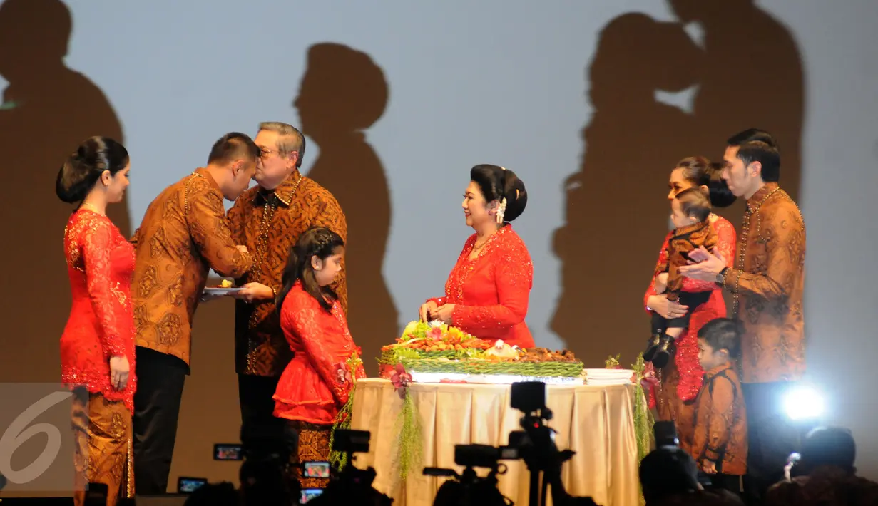 Presiden Keenam RI, Susilo Bambang Yudhoyono memberikan tumpeng perayaanT 40 tahun penikahannya dengan Kristiani Herrawati kepada putra pertamanya, Agus Harimurti Yudhoyono di Jakarta, Sabtu (30/7). (Liputan6.com/Helmi Fithriansyah)