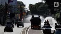 Mobil Water Cannon milik Polisi menyemprotkan Disinfektan di jalan Slipi, Jakarta, Selasa (31/3/2020). Meluasnya Covid-19 membuat petugas kepolisian Berinisiatif menyemprotkan Disinfektan menggunakan Water Cannon memutari jalan, Petamburan, Slipi Raya Jakarta Barat. (Liputan6.com/Johan Tallo)