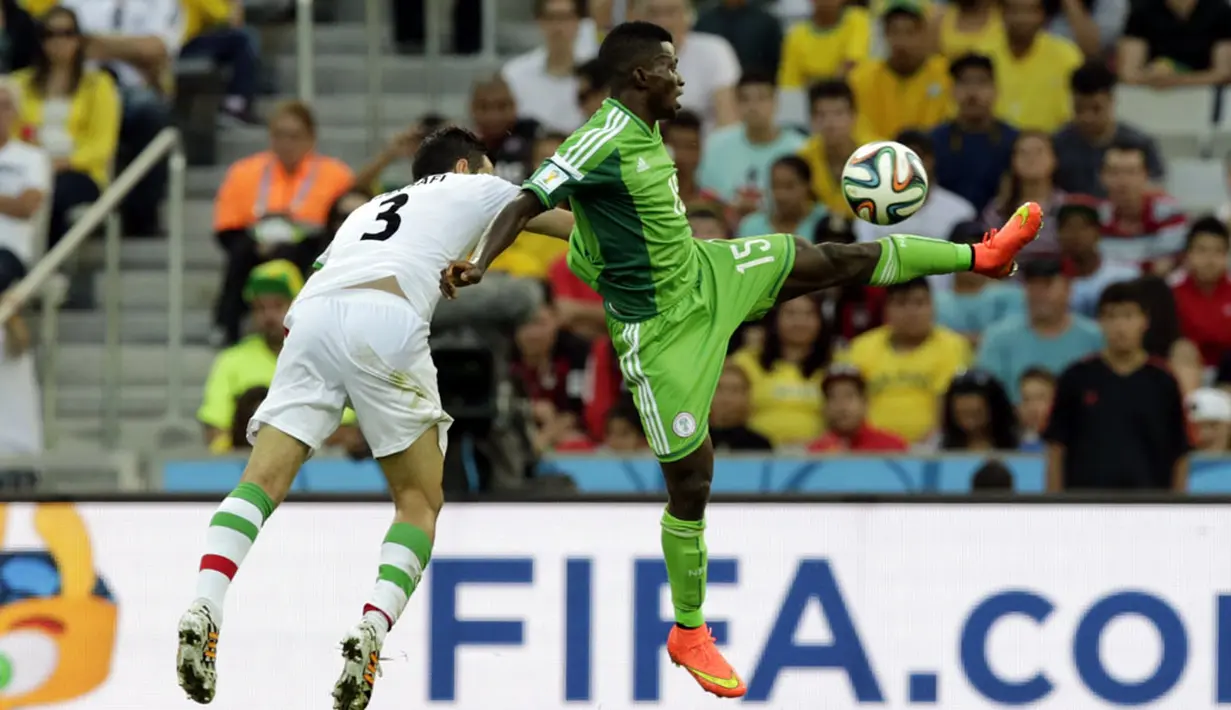 Pemain belakang Iran, Ehsan Hajsafi (kiri) mencoba menahan pergerakan Ramon Azeez (Nigeria) saat berlaga di babak penyisihan Piala Dunia Grup F, Baixada Arena, Brasil, (17/6/2014). (REUTERS/Henry Romero)