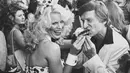 Model Playboy Bunny Betsy menyuapi Hugh Hefner sebuah kue di Hollywood walk of fame, Los Angeles, California, pada 9 April 1980. Hefner mendirikan majalah dewasa Playboy tahun 1953 dengan foto toples Marilyn Monroe diedisi pertamanya. (AP Photo / Loundy)