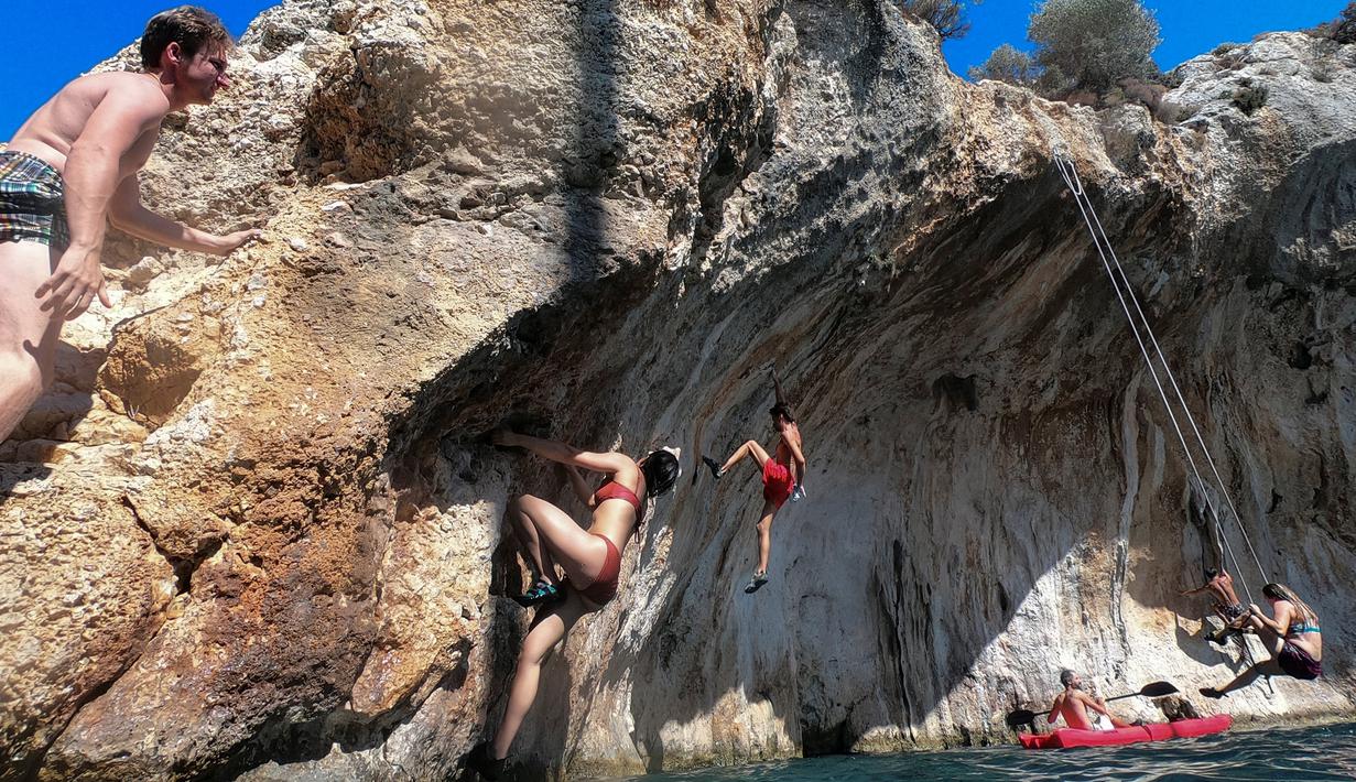 Peserta berpartisipasi dalam Festival Mendaki tahunan 2019 di pulau Kalymnos, Yunani (4/10/2019). Pemandangan menakjubkan dan cuaca bagus menjadikan pulau ini sebagai tujuan utama bagi pemanjat tebing internasional dari semua tingkatan dengan lebih dari 2500 rute pendakian. (AFP Photo/Aris Messinis)