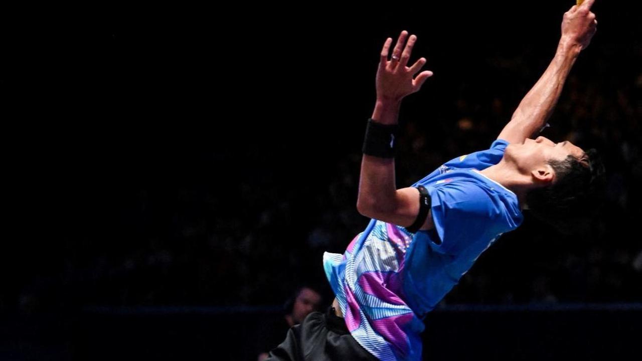 Aksi Jonatan saat melakukan smash kepada Ginting. Foto: JUSTIN TALLIS / AFP