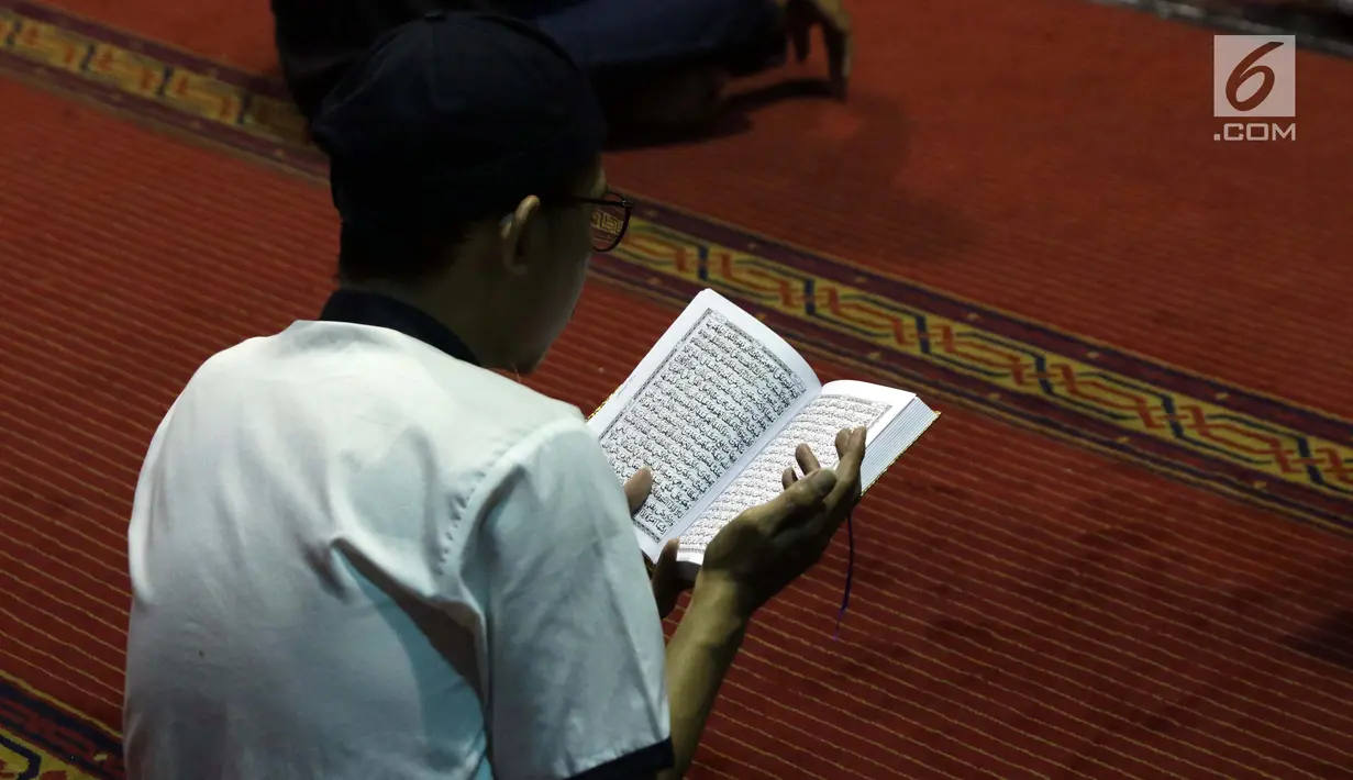 Umat muslim membaca Alquran saat malam takbiran di Masjid Istiqlal, Jakarta, Selasa (4/6/2019). Ratusan umat muslim berdatangan ke Masjid Istiqlal untuk merayakan malam takbir jelang melaksanakan salat Idul Fitri 1440 Hijriah. (Liputan6.com/Helmi Fithriansyah)