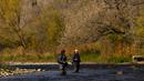 Seorang nelayan melemparkan pancingnya saat dia memancing ikan trout di Credit River di antara warna-warni musim gugur di Mississauga, Ontario, pada Kamis, 27 Oktober 2022. (Nathan Denette/The Canadian Press via AP)
