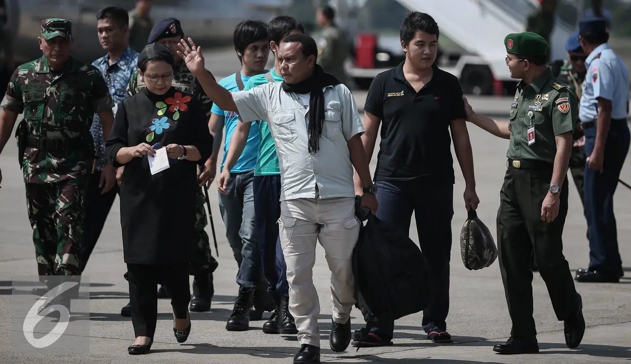 Empat WNI yang sempat disandera Abu Sayyaf melambaikan tangan kepada wartawan saat tiba di Lanud Halim Perdanakusuma, Jakarta, Jumat (13/5). Keempat WNI merupakan ABK dari Kapal Tunda TB Henry dan Kapal Tongkang Cristi. (Liputan6.com/Faizal Fanani)