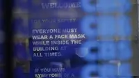 Sebuah tanda mengingatkan orang-orang bahwa masker diperlukan di sebuah gedung perkantoran di Times Square New York, Senin (13/12/2021). Wajib masker di semua tempat umum dalam ruangan di seluruh New York mulai berlaku pada Senin ketika lonjakan kasus COVID-19 dan rawat inap. (AP Photo/Seth Wenig)