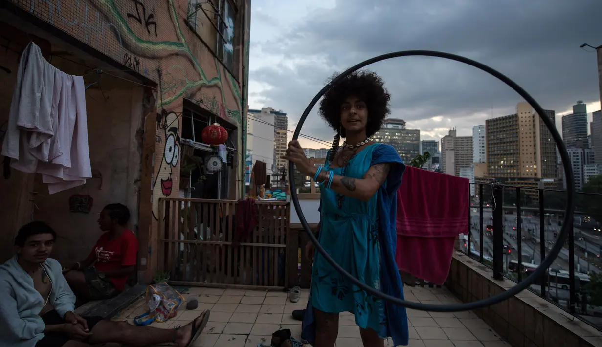 Seorang wanita bermain hula hoop di teras gedung 'Ocupa Ouvidor 63' di Sao Paulo, Brasil (28/6). Dapat dikatakan gedung tersebut kini menjadi salah satu  pusat seni di kota Sao Paulo. (AFP Photo/Nelson Almeida)