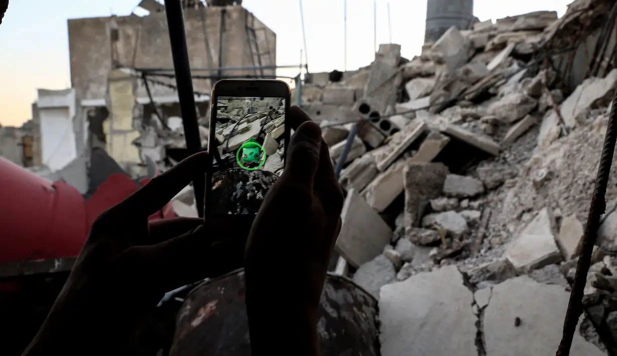 Daerah konflik di Suriah yang penuh dengan puing dan reruntuhan bangunan dijadikan tempat untuk bermain Pokemon Go oleh seorang gamer Suriah, Damaskus (23/7). (AFP PHOTO / Sameer Al-Doumy)