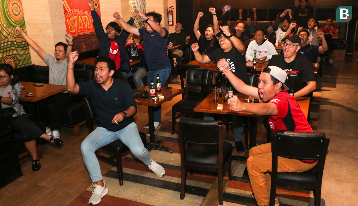 Pendukung Manchester United merayakan gol yang dicetak oleh Alejandro Garnacho ke gawang West Ham saat acara Roaring Night yang berlangsung di Fomo Bar, Melawai, Jakarta, Minggu (04/02/2024) malam WIB. (Bola.com/Bagaskara Lazuardi)