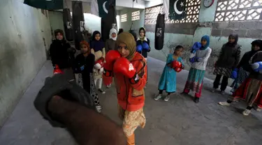 Seorang gadis Pakistan bernama Anum saat berlatih bersama pelatih tinjunya di kamp tinju wanita, Karachi , Pakistan, (20/2). Tempat latihan tinju khusus wanita ini adalah yang pertama yang ada di Pakistan. (REUTERS / Akhtar Soomro)