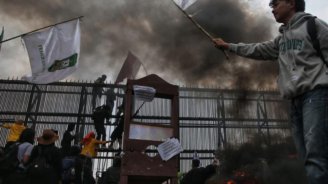 Aksi unjuk rasa menolak pengesahan revisi UU Pilkada di Gedung DPR, Jakarta, mulai membara, pada Kamis (22/8/2024). Massa pendemo terpantau membakar ban di depan gerbang utama Gedung DPR.&nbsp;Foto: Liputan6.com/Angga Yuniar