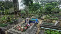 Ziarah makam ini biasanya dilakukan ke pemakaman keluarga ataupun kerabat dekat. Tampak dalam foto, warga saat berziarah di makam keluarganya di Tempat Pemakaman Umum (TPU) Dreded, Bogor, Jawa Barat, Minggu (15/2/2026). (merdeka.com/Arie Basuki)