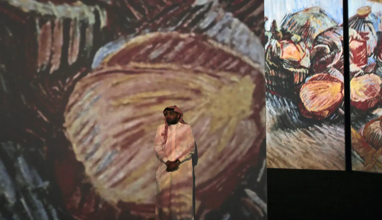 Seorang pengunjung pria berdiri di depan  lukisan Vincent van Gogh versi digital di Dubai, Uni Emirat Arab, Minggu (11/3). Pameran ini bertema Van Gogh Alive. (AP Photo/Kamran Jebreili)