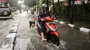 Warga membantu mendorong motor saat melewati banjir di kawasan Kemang, Jakarta, Jumat (11/11). (Liputan6.com/Yoppy Renato)