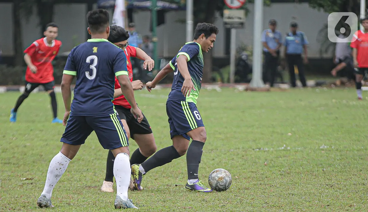 Pemain tim fraksi Gerinda berebut bola dengan pemain tim Gedung Taman DPR saat pertandingan dalam rangkaian HUT Gerindra ke-15 di Lapangan Sepak bola DPR RI, Jakarta, Selasa (31/1/2023). Sejumlah kegiatan dilaksanakan dalam rangkaian HUT Gerinda Ke-15 yang digelar sederhana dan tidak secara foya-foya. (Liputan6.com/Faizal Fanani)