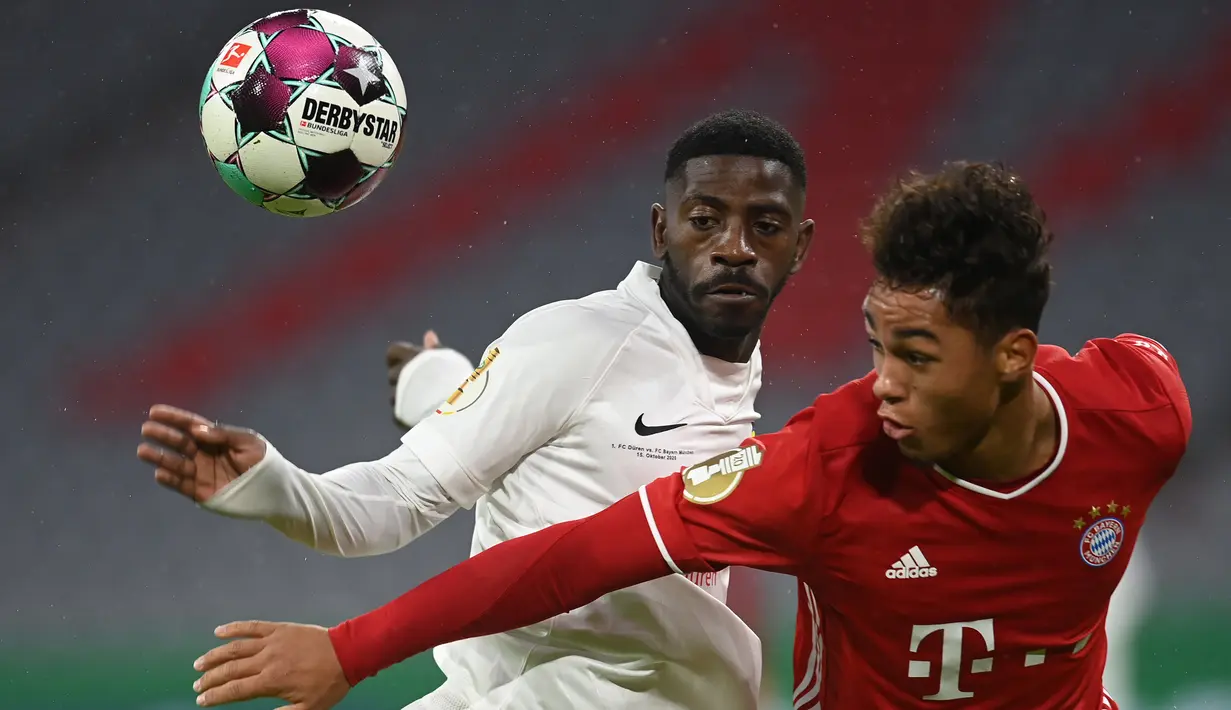 Penyerang Bayern Munchen, Armindo Sieb, berebut bola dengan bek Duren Merzenich, Guenter Mabanza, pada laga DFB Pokal di Stadion Allianz Arena, Jumat (16/10/2020) dini hari WIB. Bayern Munchen menang 3-0 atas Duren Merzenich. (AFP/Christof Stache)