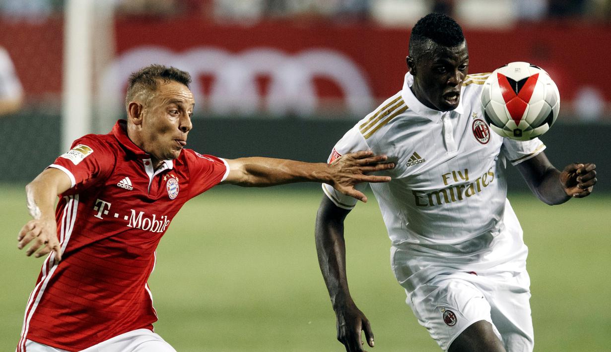 Pemain AC Milan, Mbaye Niang, berebut bola dengan pemain Bayern Munchen, Rafinha, dalam International Champions Cup 2016 di Soldier Field, Chicago, Kamis (28/7/2016) pagi WIB. (EPA/John Gress)