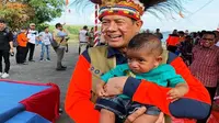 Kepala BNPB Doni Monardo sedang menggendong 'Doni Monardo' kecil saat acara Kebersamaan dalam se-Helai Papeda di Bumi Kenambai Umbai, Sentani, Jayapura, Selasa (3/9/2019). (Dok Badan Nasional Penanggulangan Bencana/BNPB)