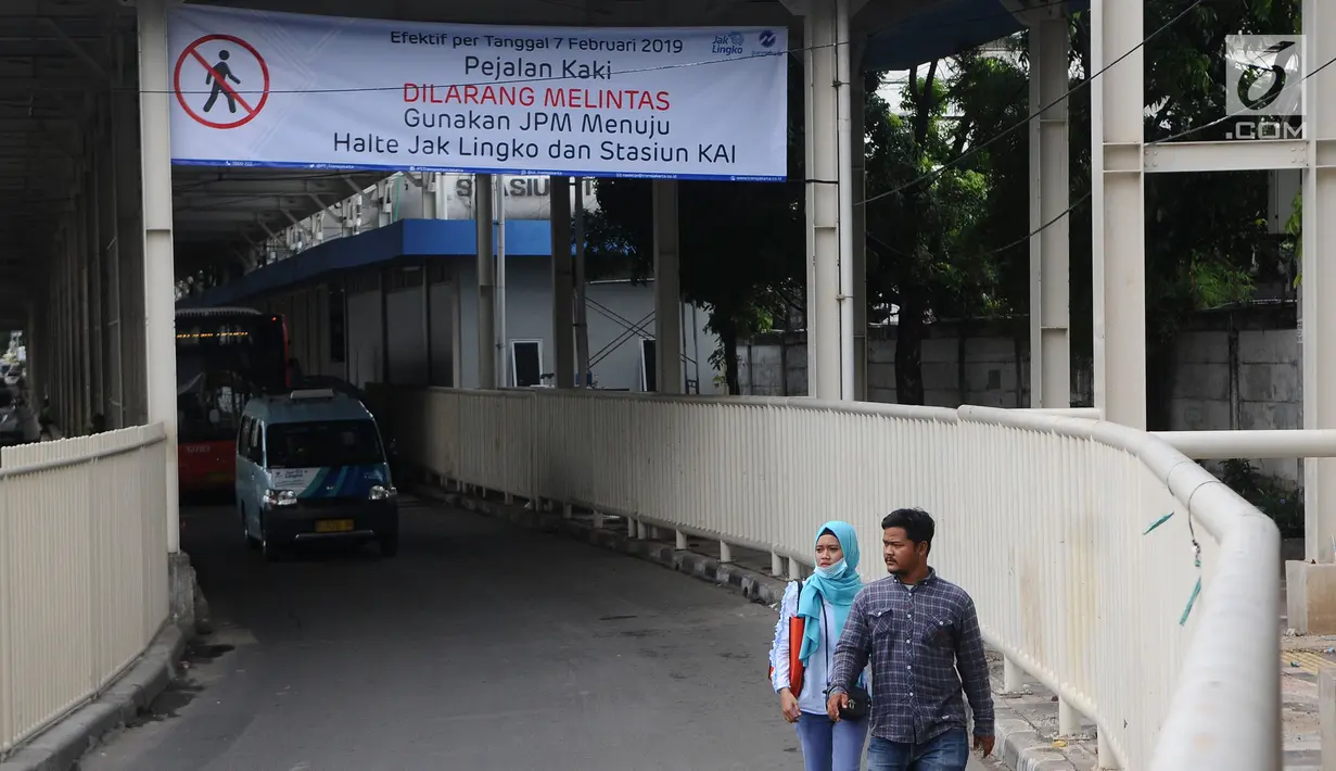 Pejalan kaki melintas di bawah jembatan penyeberangan multiguna (JPM) atau Skybridge Tanah Abang, Jakarta, Kamis (7/2). Mulai 7 Februari 2019, pejalan kaki yang menuju dan dari Stasiun Tanah Abang harus mengakses skybridge. (Liputan6.com/Herman Zakharia)