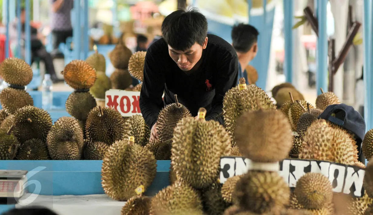 Pedagang merapihkan durian daganganya di Lokasi Sementara (Loksem) Pusat Penjualan Durian, Jalan TMP Kalibata, Jakarta Selatan, Kamis (9/2). Pemprov DKI Jakarta bangun Loksem Pusat Penjualan Durian di Kalibata. (Liputan6.com/Yoppy Renato)
