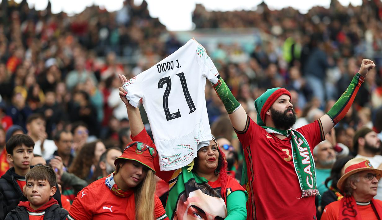 Suporter Portugal mengangkat jersey bertuliskan mendiang Diogo Jota saat menyaksikan laga Grup F Kualifikasi Piala Dunia 2026 antara Portugal melawan Armenia di Dragao Stadium, Porto, Minggu (16/11/2025) waktu setempat. (AP Photo/Luis Vieira)