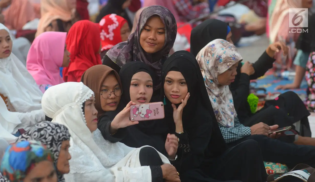 Warga berselfie sebelum salat Idul Fitri 1439 H di Pelabuhan Sunda Kelapa, Jakarta, Jumat (15/6). Seluruh umat islam merayakan hari Idul Fitri 1349 H yang jatuh pada Jumat, 15 Juni 2018.            (Merdeka.com/Imam Buhori)