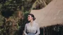 Cantiknya penampilan Ariel Tatum dibalut kebaya putih yang sederhana. Penampilannya bak gadis Bali, dilengkapi dengan kain batik sebagai rok dan selendang biru yang diikatkan di pinggangnya. [Foto: Instagram/arieltatum]