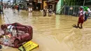 Sejumlah warga melintasi banjir yang merendam komplek Pondok Gede Permai, Jatiasih, Bekasi, Jumat (22/4). Banjir yang sempat mencapai 4 meter di perumahan tersebut merendam lebih dari 500 rumah yang dihuni ribuan warga. (Liputan6.com/Fery Pradolo)