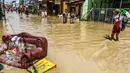 Sejumlah warga melintasi banjir yang merendam komplek Pondok Gede Permai, Jatiasih, Bekasi, Jumat (22/4). Banjir yang sempat mencapai 4 meter di perumahan tersebut merendam lebih dari 500 rumah yang dihuni ribuan warga. (Liputan6.com/Fery Pradolo)