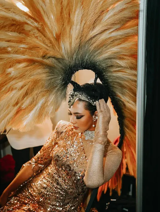 Dress berpotongan asimetris itu dipadukan dengan headpiece berbulu yang besar.  [@martinusmunindra/@paula_verhoeven].