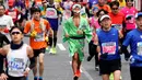 Pelari berkostum tradisional melintas di distrik perbelanjaan Ginza saat ambil bagian dalam Tokyo Marathon 2018 , Minggu (25/2). Tokyo Marathon merupakan ajang bergengsi lari kelas dunia yang diikuti pelari dari berbagai negara. (AP/Shizuo Kambayashi)