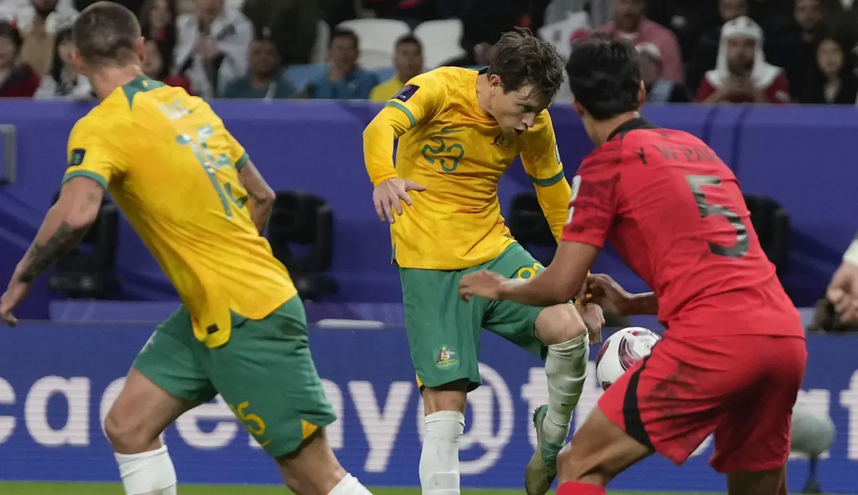 Striker Timnas Australia, Craig Goodwin (tengah) melepaskan tendangan yang menghasilkan gol ke gawang Korea Selatan pada laga perempatfinal Piala Asia 2023 di Al Janoub Stadium, Al Wakrah, Qatar, Jumat (2/2/2024) malam waktu setempat. (AP Photo/Thanassis Stavrakis)