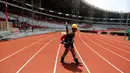 Pekerja berjalan di lintasan lari Stadion Utama Gelora Bung Karno, Jakarta, Selasa (3/10). Renovasi untuk Asian Games 2018 dengan nilai kontrak yang ditaksir mencapai Rp 769,7 miliar ini ditarget rampung pada Desember 2017. (Liputan6.com/Johan Tallo)