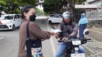Pembagian masker gratis dan edukasi protokol kesehatan oleh jurnalis Kota Palu untuk membantu menekan penyebaran Covid-19. (Foto: Heri Susanto/ Liputan6.com).