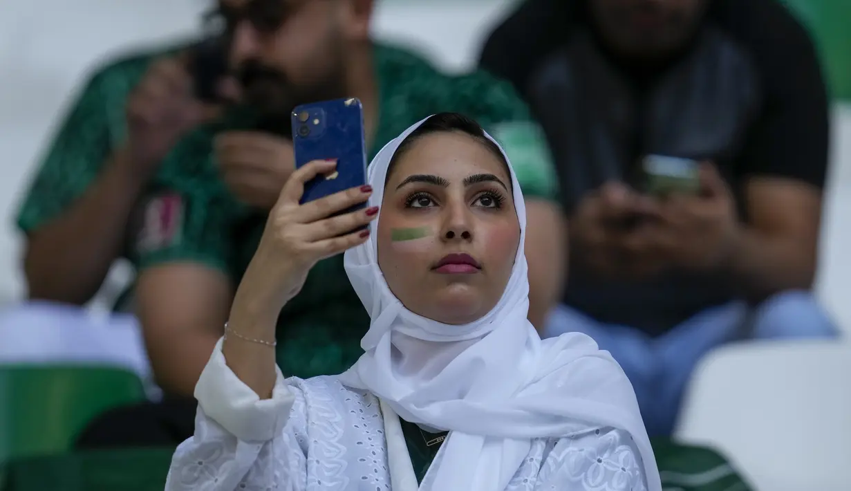 Seorang fans Arab Saudi menggunakan ponselnya menjelang pertandingan grup C Piala Dunia antara Polandia dan Arab Saudi, di Education City Stadium di Al Rayyan, Qatar, Sabtu, 26 November 2022. (AP Photo/Darko Vojinovic)