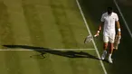 Petenis Serbia, Novak Djokovic berjalan di lapangan pada babak perempatfinal Wimbledon 2017 saat bertemu petenis Ceko, Tomas Berdych, Rabu (12/7). Djokovic memutuskan mundur setelah mengalami cedera siku saat menjalani pertandingan. (AP/Alastair Grant)