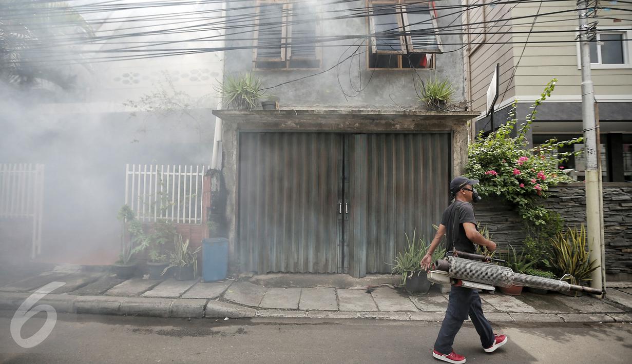 Petugas melakukan pengasapan (fogging) di kelurahan Menteng, Jakarta, Senin (8/2). Pengasapan oleh petugas puskesmas setempat itu dilakukan untuk mencegah wabah penyakit demam berdarah yang kerap muncul pada peralihan musim. (Liputan6.com/Faizal Fanani)