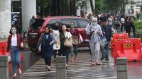 Pekerja berjalan kaki saat jam pulang di kawasan Sudirman, Jakarta, Jumat (7/2/2020). BPJS Ketenagakerjaan yang kini bernama BP Jamsostek menargetkan sekitar 23,5 juta tenaga kerja baru masuk dalam daftar kepesertaan pada 2020. (Liputan6.com/Angga Yuniar)